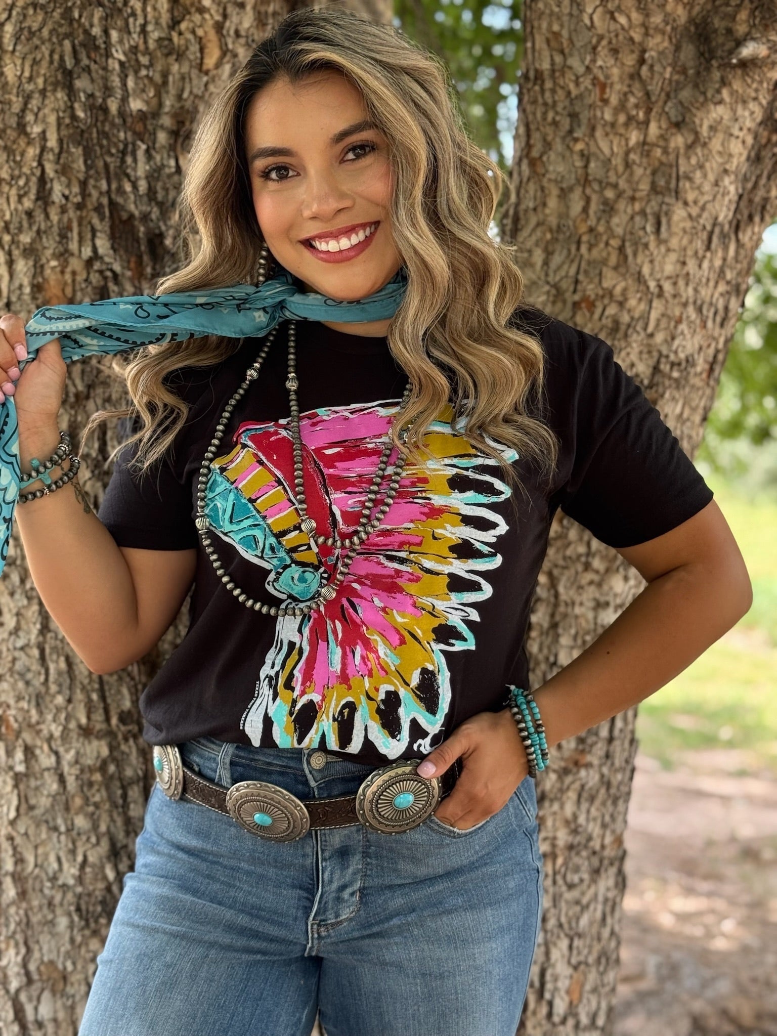 Woman wearing a colorful shirt with a tree in the background