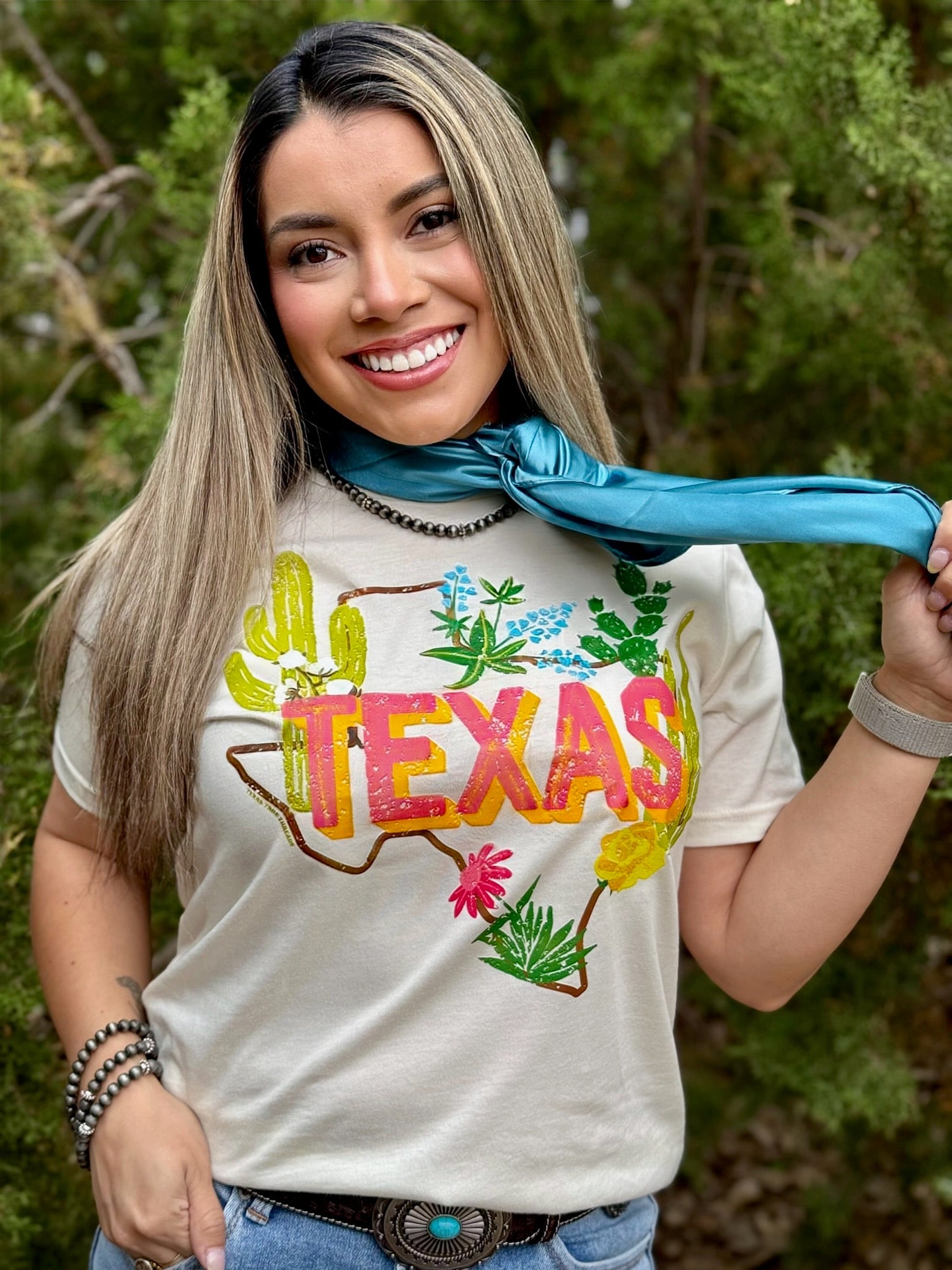 Woman wearing a 'TEXAS' t-shirt with colorful graphics outdoors