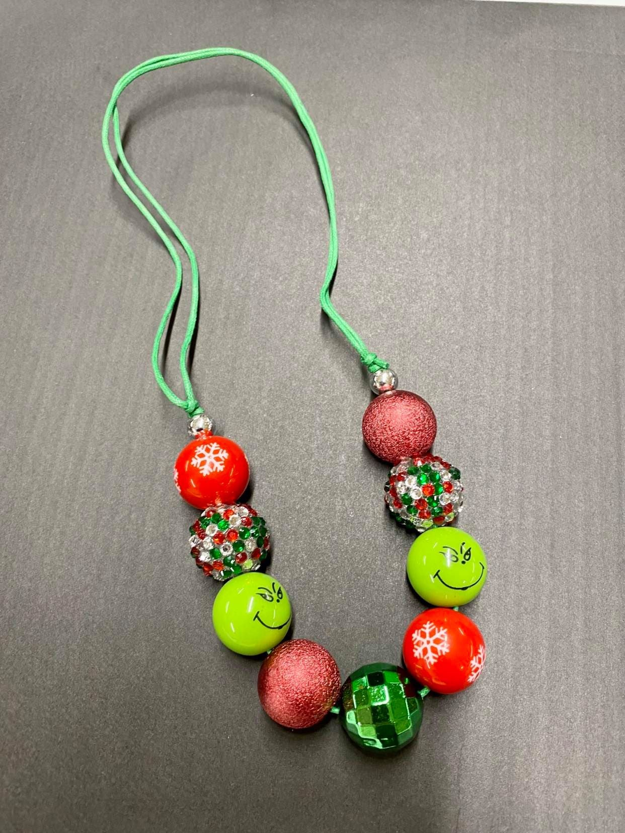 Red snowflake, sequin, Grinch, and glitter orb necklace